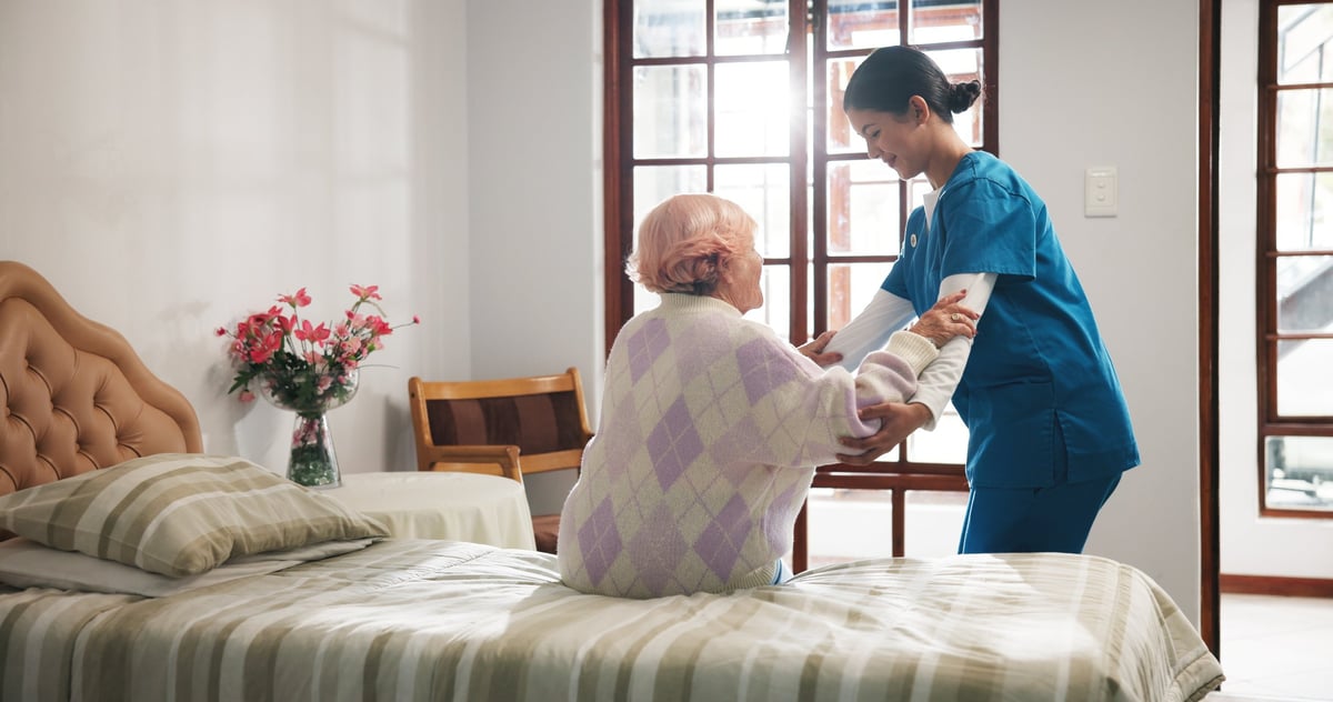 A caregiver assists a senior woman at home