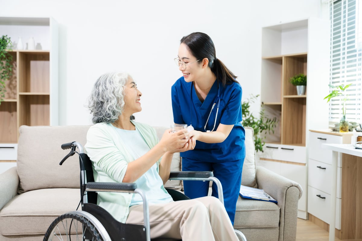 A caregiver helps a senior woman in her home
